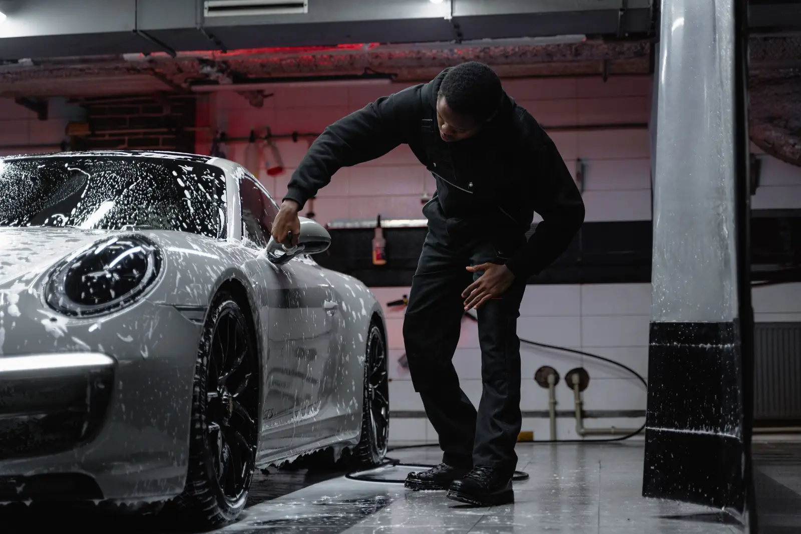 Detailer foam-washing a car at AquaGlow